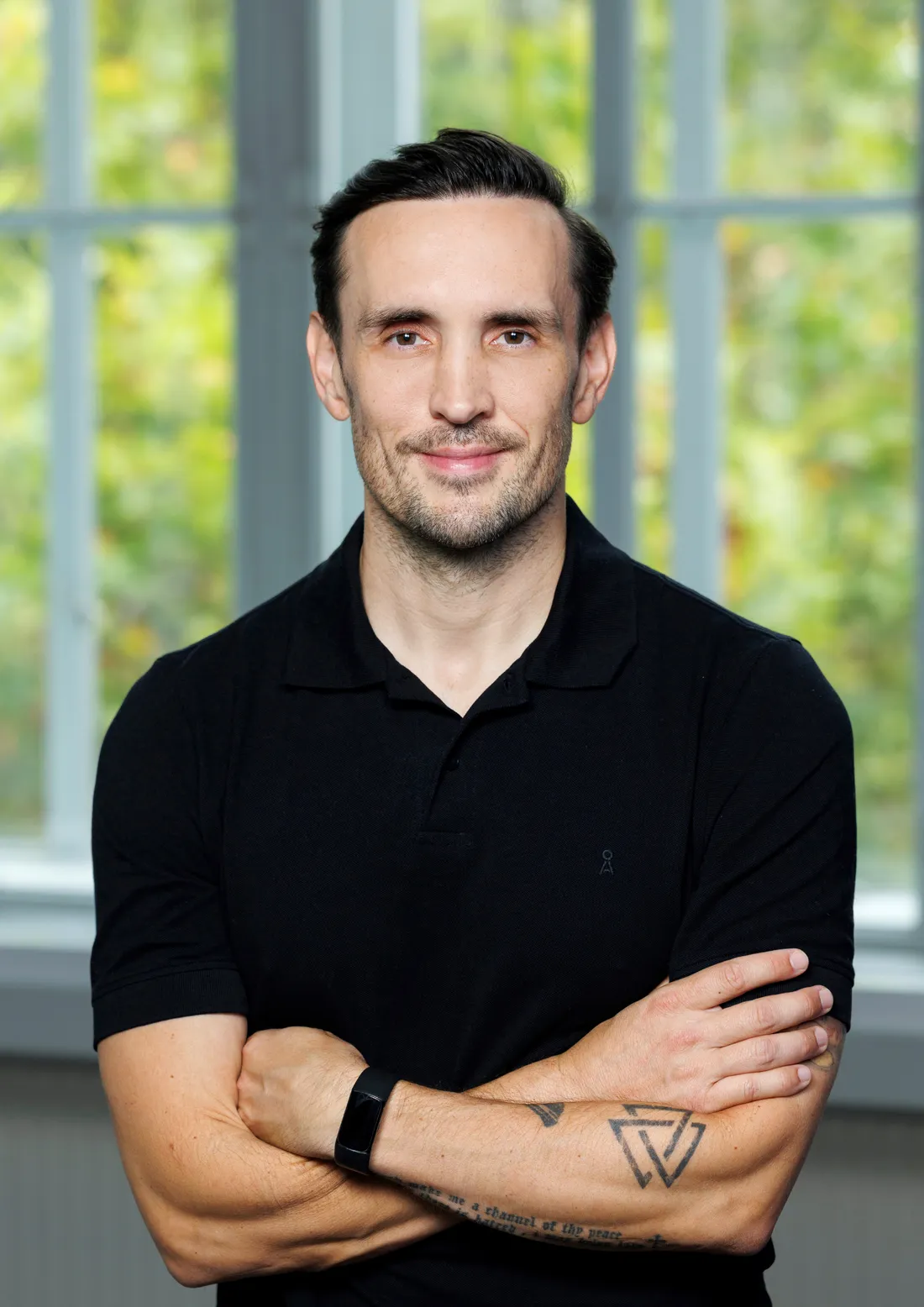 Professor Brendon Stubbs, arms folded, standing by a window
